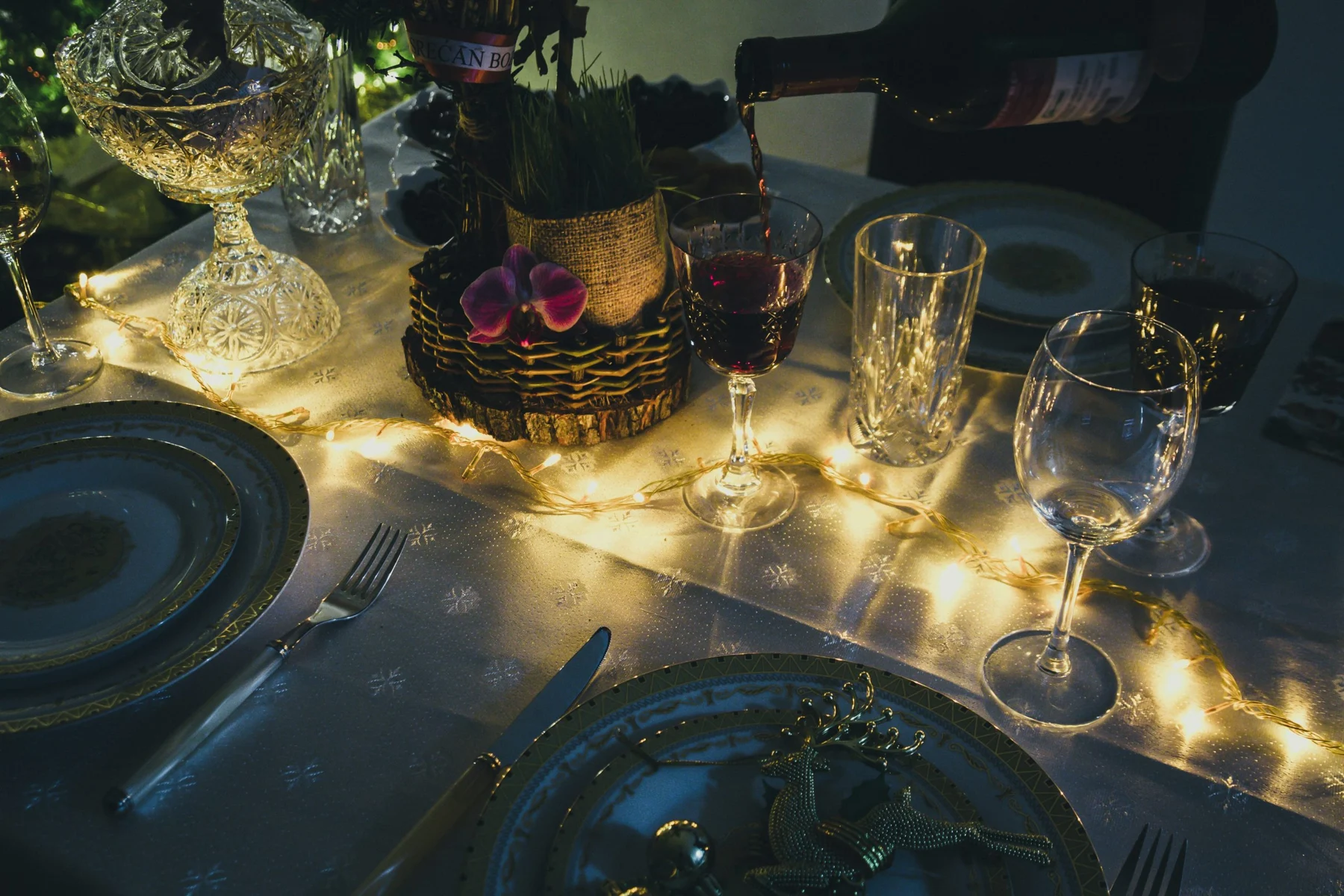 Festive table set with fairy lights and glassware